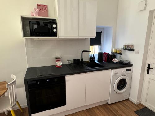 une cuisine avec un évier et un micro-ondes dans l'établissement Le POP au 17, appartement cosy dans le centre historique de Rodez, à Rodez