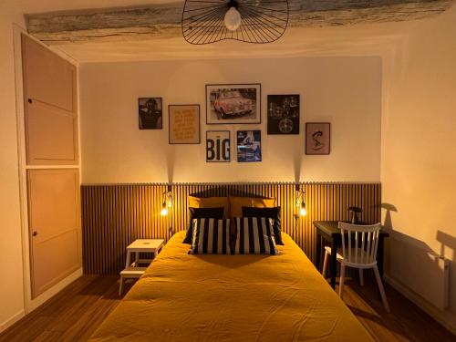 une chambre avec un lit et une table avec une chaise dans l'établissement Le POP au 17, appartement cosy dans le centre historique de Rodez, à Rodez