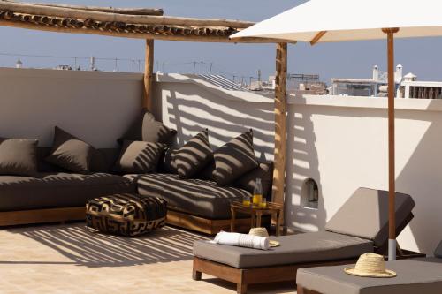 a living room with a couch and an umbrella at Maison 250 - Adult Only in Essaouira