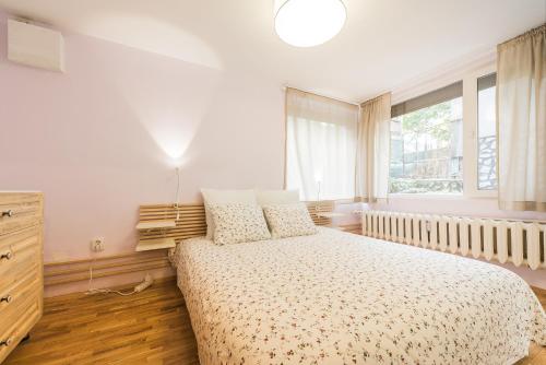 a white bedroom with a bed and a window at Stylish apartment, Top center! in Sofia