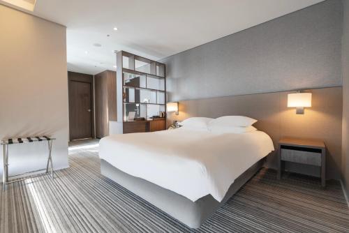 a large white bed in a hotel room at Northharbor Hotel in Busan