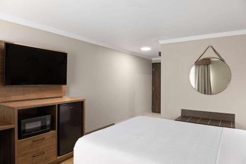 a bedroom with a bed and a flat screen tv at La Quinta Inn & Suites by Wyndham Yakima Downtown in Yakima