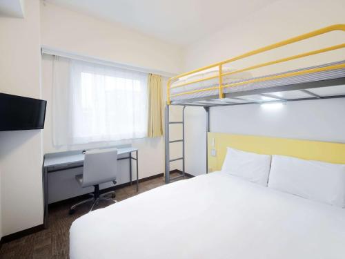 a bedroom with a bed and a desk and a bunk bed at Comfort Inn Tosu in Tosu