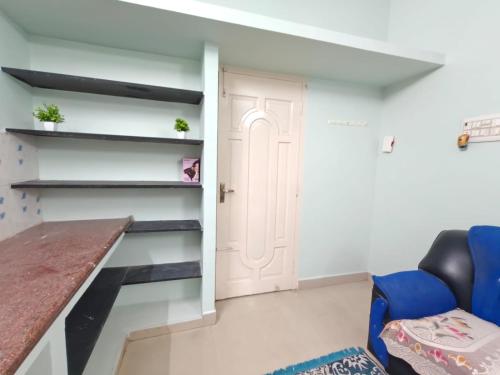 a room with a desk and a blue chair at Maison Douce in Chennai