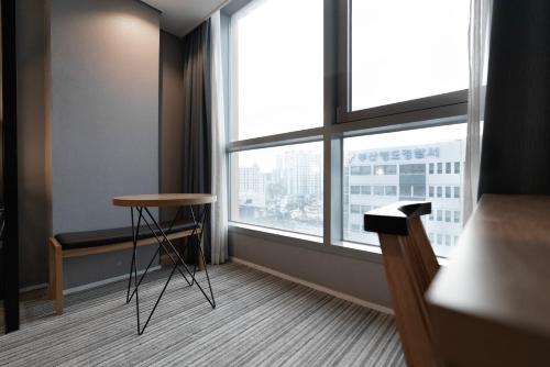 a room with a table and a large window at Northharbor Hotel in Busan