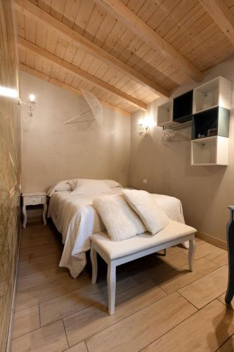 a bedroom with a white bed and a wooden ceiling at Camping Camplani in Zone
