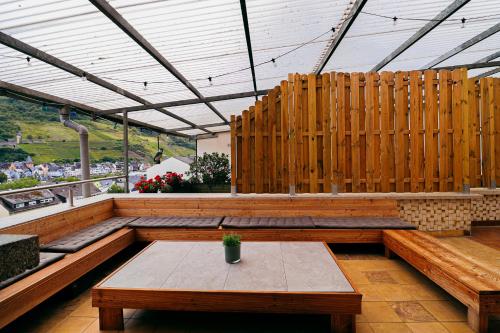 a patio with wooden benches and a table at Chill Out Area, Sauna & Wirlpool, grandiose Aussicht, Smart TV, Netflix in Zell an der Mosel