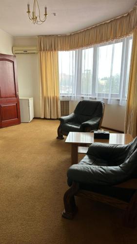 a living room with two chairs and a table at Момент in Yuzhnoukrainsk 