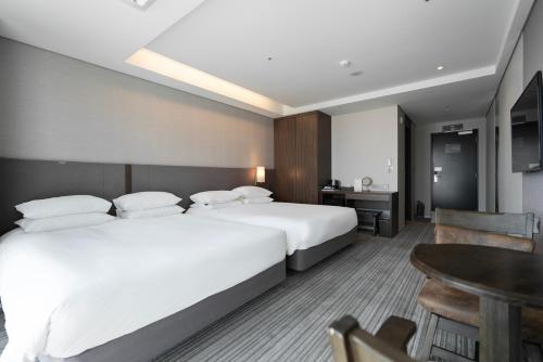 a hotel room with two beds and a table at Northharbor Hotel in Busan