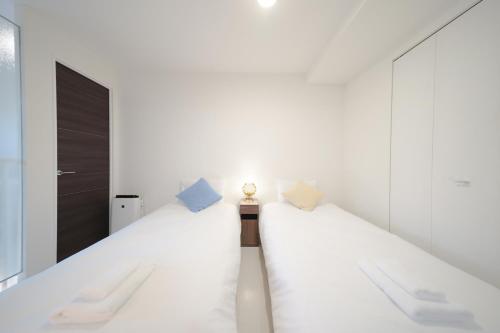 a room with a long bed with two pillows at Pillowbook Accommodations Otaru Kaihoro 106 in Otaru
