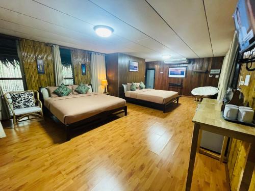 a room with two beds and a couch in it at บ้านริมเลปากประ Banrimlay Pakpra in Phatthalung
