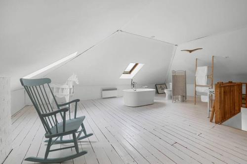 a white room with a chair and a tub in it at Ruralité au Cœur de la Ville in Quebec City