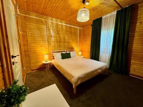 a bedroom with a bed in a wooden room at Sofia Lake House in Lunca Mare