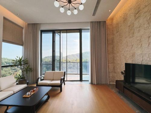 a living room with a couch and a tv at 莫干山云上别墅 in Houhong