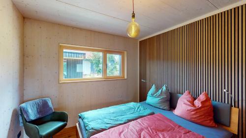 Un dormitorio con una cama y una silla y una ventana. en Villa SEE la vie, en Rheinsberg