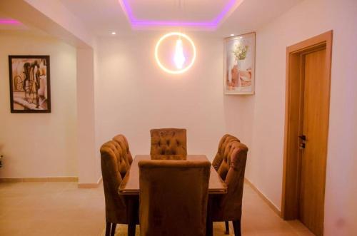 a dining room with a wooden table and chairs at House 103 Abuja in Abuja