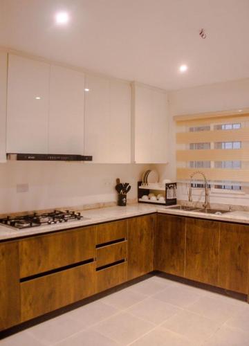 a kitchen with white cabinets and a stove top oven at House 103 Abuja in Abuja