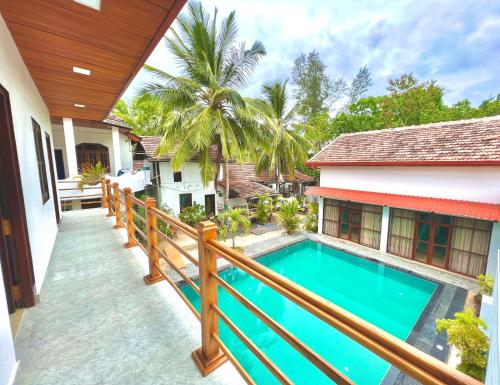 a balcony with a swimming pool and a house at Maccan's Village in Arugam Bay