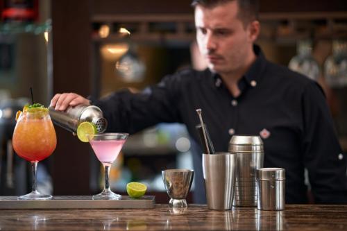 a man bartender making a drink at a bar at Maison Hotel in Halkidona