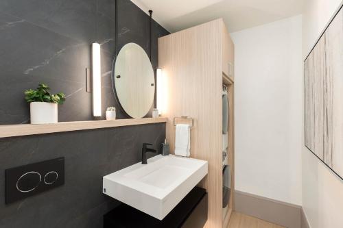 a bathroom with a white sink and a mirror at New 2 BR 2 and a half Bath - Luxurious Aspen Mountain Modern! in Aspen