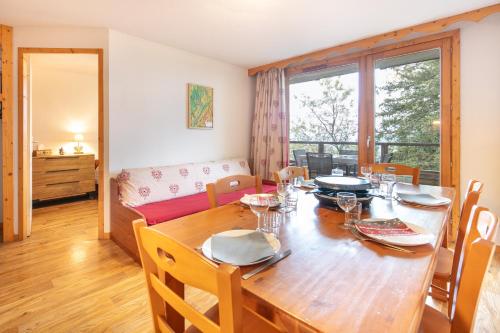 une salle à manger avec une table, des chaises et un canapé dans l'établissement Roche et Neige - Proche remontées mécaniques, à Chamrousse