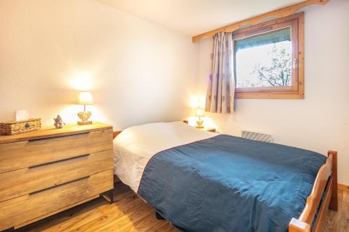 a bedroom with a bed and a dresser and a window at Roche et Neige - Proche remontées mécaniques in Chamrousse