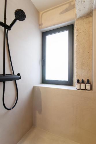 a shower in a bathroom with a window at Isoyio in Piraeus