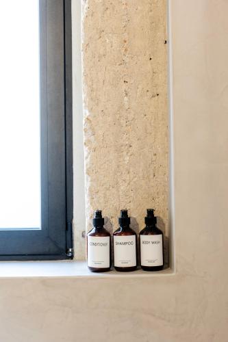 three bottles of medicine sitting on a window sill at Isoyio in Piraeus