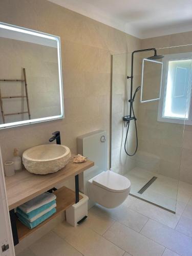 a bathroom with a toilet and a sink and a shower at Bonaire Beach House in Alcudia