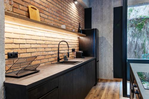 a kitchen with a sink and a brick wall at Isoyio in Piraeus