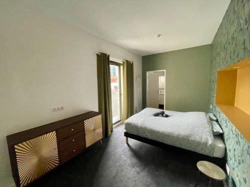 une chambre avec un lit et une grande fenêtre dans l'établissement Séjour Art Nouveau au coeur de Wazemmes, à Lille