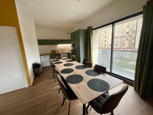 une salle de conférence avec une longue table et des chaises dans l'établissement Séjour Art Nouveau au coeur de Wazemmes, à Lille