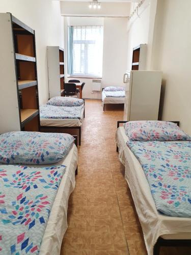 a room with three beds in a room at Ubytovna Moravan Brno in Brno
