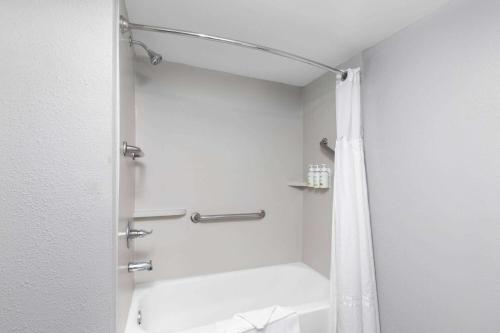a bathroom with a shower with a shower curtain at Baymont by Wyndham Mobile/Tillmans Corner in Tillmans Corner