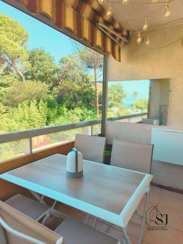 - une table et des chaises dans une chambre avec vue dans l'établissement Très bel Appartement Le Santa Lucia à SAINT-RAPAËL - Confort, Climatisation et Vue mer !, à Ampuis