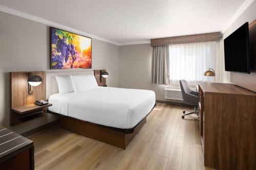 a hotel room with a large bed and a desk at La Quinta Inn & Suites by Wyndham Yakima Downtown in Yakima