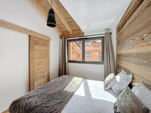 une chambre avec un lit et une fenêtre dans l'établissement Celadon - appartement- 4 pers - proche centre, aux Gets