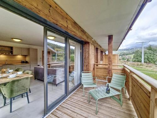 Cette chambre dispose d'un balcon avec une table et des chaises. dans l'établissement Sika-appartement-6pers-Jacuzzi, aux Gets