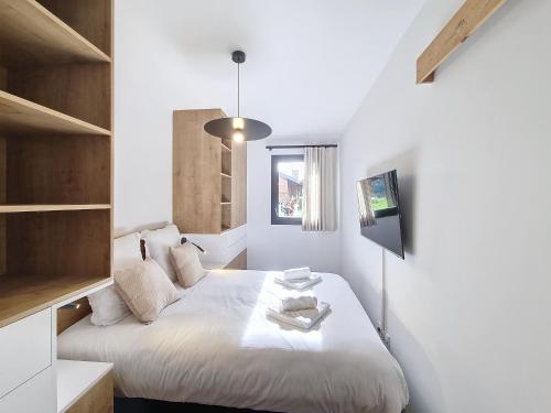 une chambre avec un lit blanc et une fenêtre dans l'établissement Sika-appartement-6pers-Jacuzzi, aux Gets