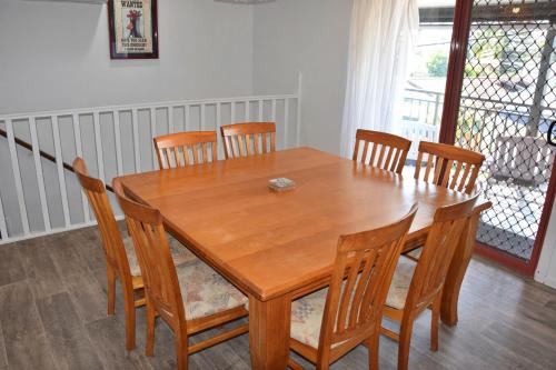 a dining room table with chairs and a wooden table at High 5 in South West Rocks