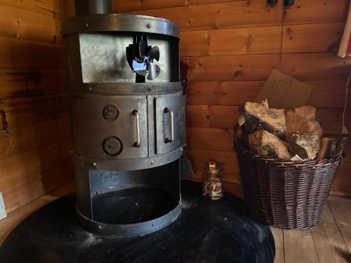 an old fashioned coffee maker with a basket of logs at Log-House Wildernest in Brande