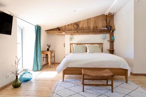 une chambre avec un grand lit avec une tête de lit en bois dans l'établissement Gîte le Saint Couette 4 étoiles, charme & confort chic, à Saint-Colombin