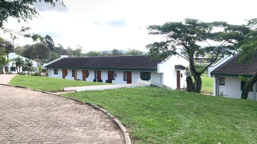 a white house with a grassy yard in front of it at Pinetown Accommodation in Pinetown