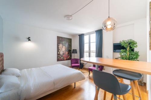 une chambre avec un lit, une table et des chaises dans l'établissement Résidence Jardin des plantes PARIS, à Paris