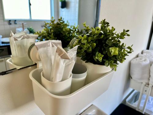 a kitchen counter with potted plants in a white holder at OMOTENASHI STAY OSAKA 41m2 1LDK 十三駅徒歩1分 梅田2分 神戸京都アクセス良好 和室のある家 in Osaka