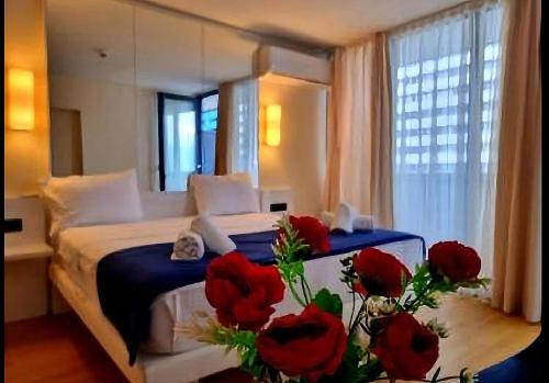 a bedroom with a bed with red roses on it at Orbi City - "A" in Batumi
