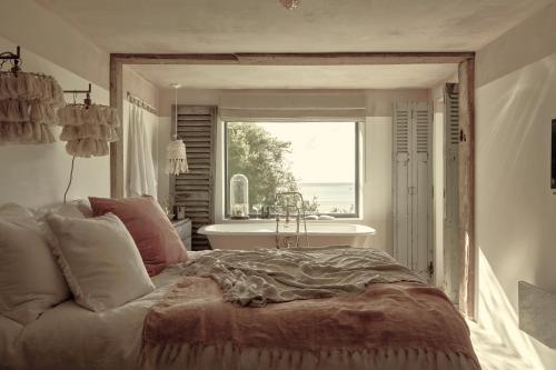a bedroom with a large bed in front of a window at The Tidal Shore - Adults Only - in Marazion