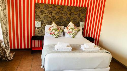 a bedroom with a bed with red and white stripes at Pinetown Accommodation in Pinetown