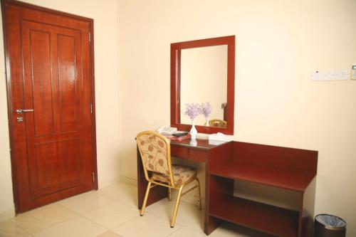 a desk with a mirror and a chair in a room at Al Ayjah Plaza Hotel in Sur