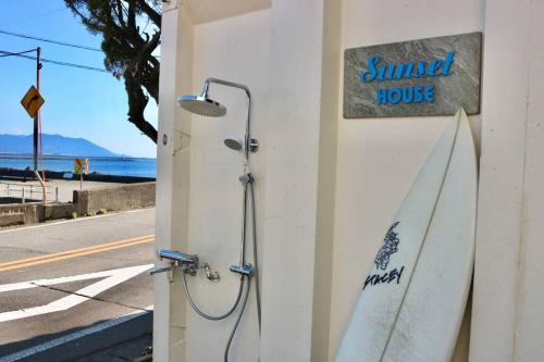 two surfboards leaning against a building with a sign on it at 三国サンセットハウス in Tōjimbō